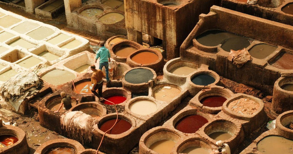 Aerial view of vibrant leather dyeing vats at traditional tanneries in Fes, Morocco.