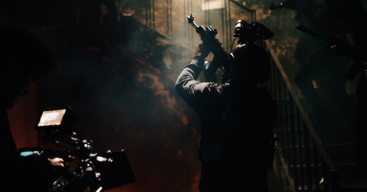 Dramatic silhouette of armed figures in a smoky, dimly lit environment, depicting a military scene.