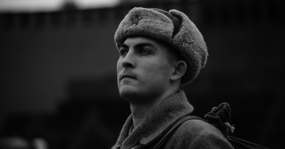 Close-up portrait of a soldier in vintage attire, gazing stoically.