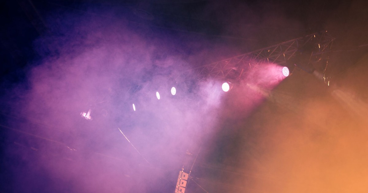 Dynamic stage scene with colorful lighting and fog, creating a vibrant atmosphere.