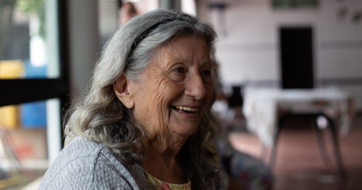 smiling woman in gray cardigan