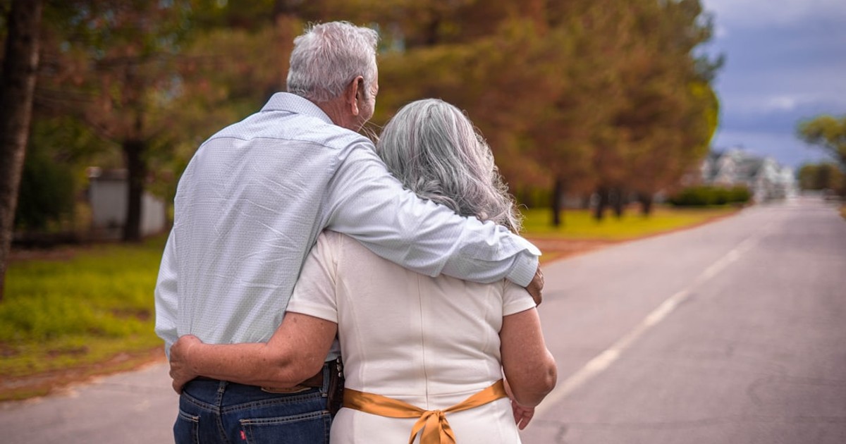 couple kissing on the road during daytime