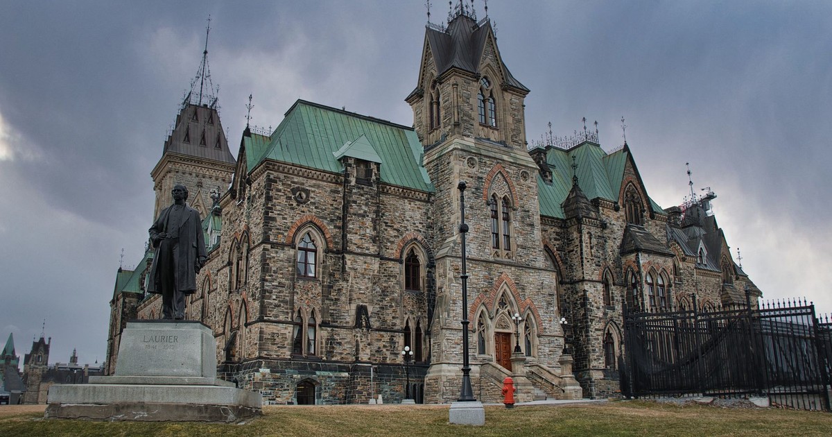 Historic Gothic revival building in Ottawa, Canada, with Laurier statue.