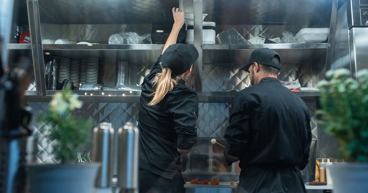 Two chefs working together in a commercial kitchen, preparing food.