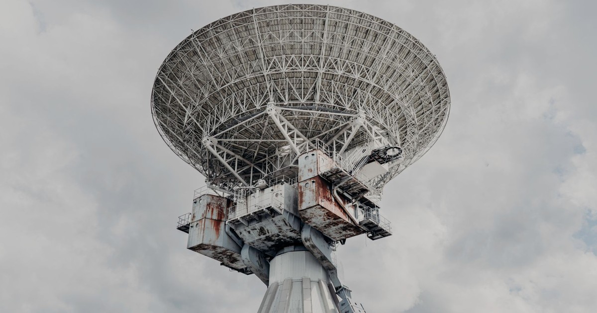 Close-up of a large radio telescope against a cloudy sky.