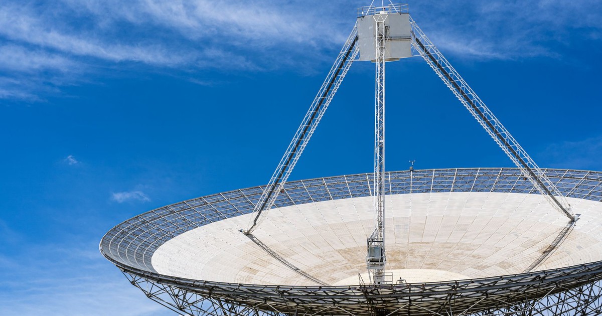 A large satellite dish with a clear blue sky in the background, showcasing modern communication technology.