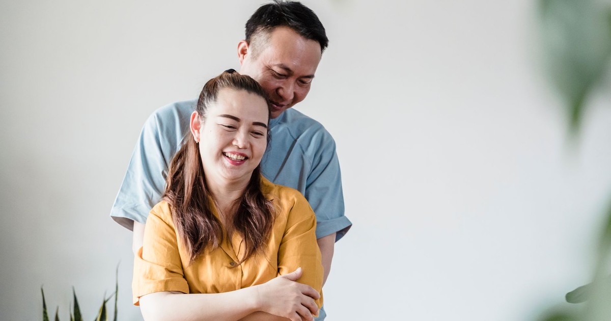 A joyful couple embracing and smiling in an indoor setting, radiating warmth and affection.