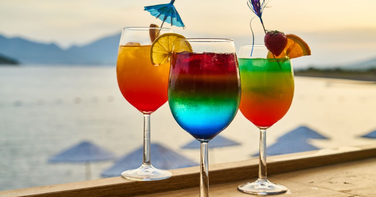 Colorful cocktails with garnishes at a sunset beach bar, perfect for tropical vacations.