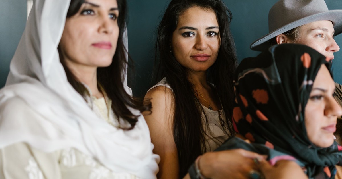 Portrait of a diverse group of women embracing different cultural attires and styles, indoors.