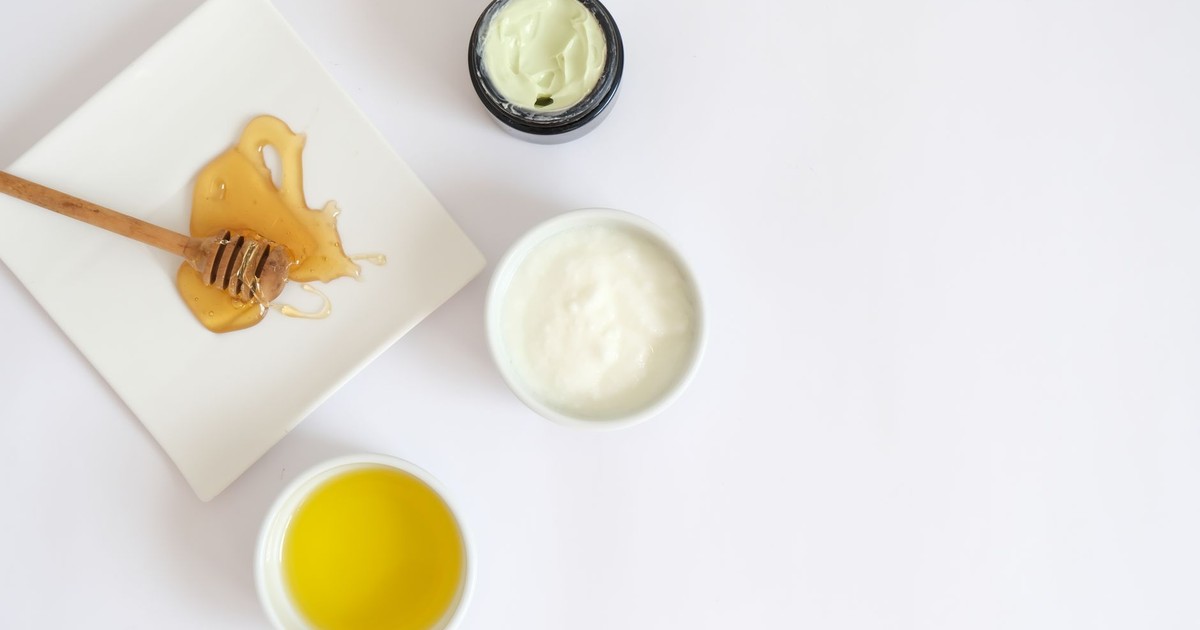 Flat lay image of honey, cream, oil, and natural ingredients for skincare.