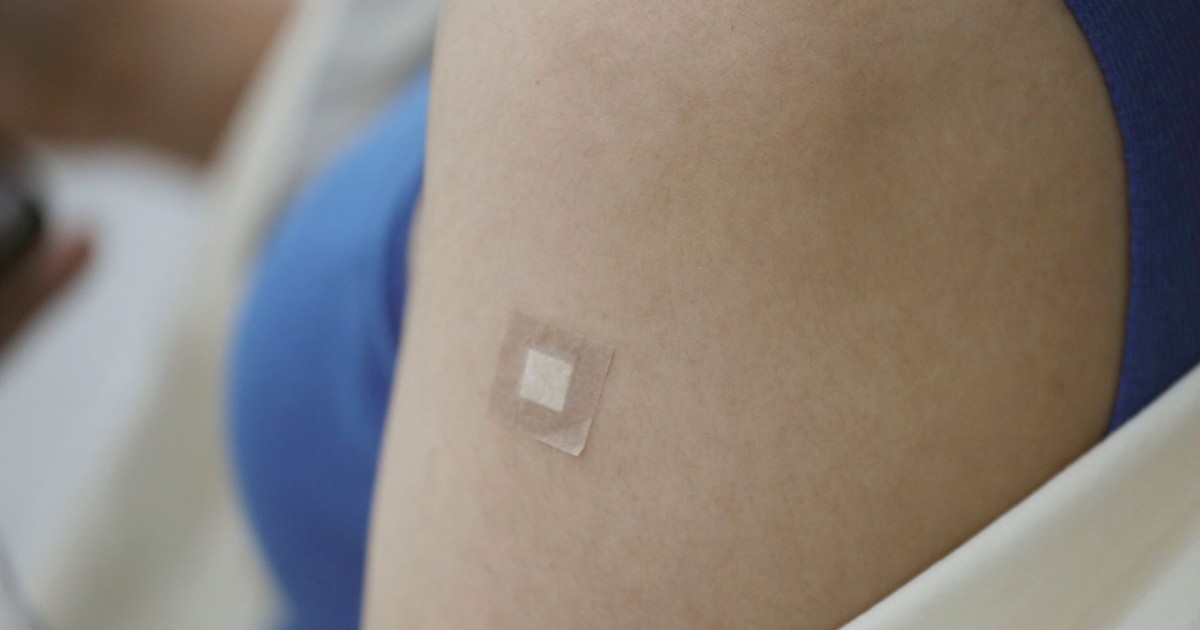 A close-up image showing a Band-Aid on an arm following a medical vaccination.