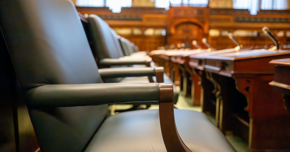 Elegant courtroom seating with leather chairs and wooden desks, exuding a sense of authority.