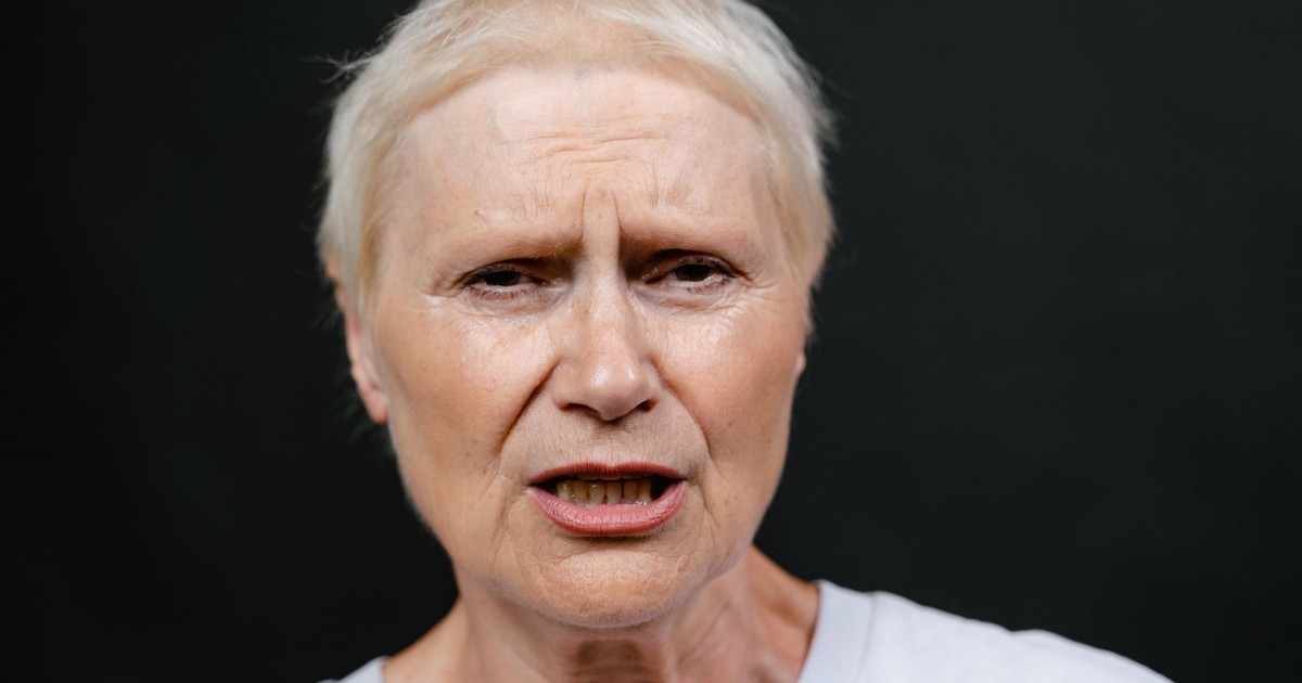 Close-up of a senior woman showing emotion and facial expression, highlighting age and experience.