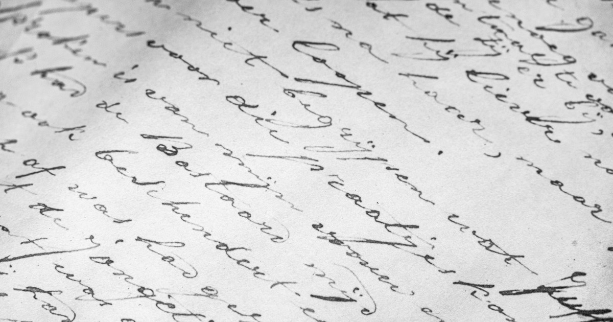Detailed close-up of vintage cursive handwriting on old paper, elegant script.