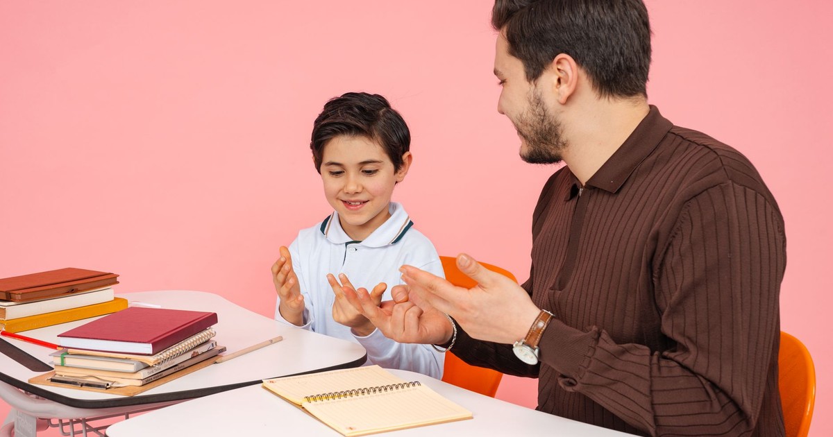 Male teacher and young student enjoying a learning session in a classroom.