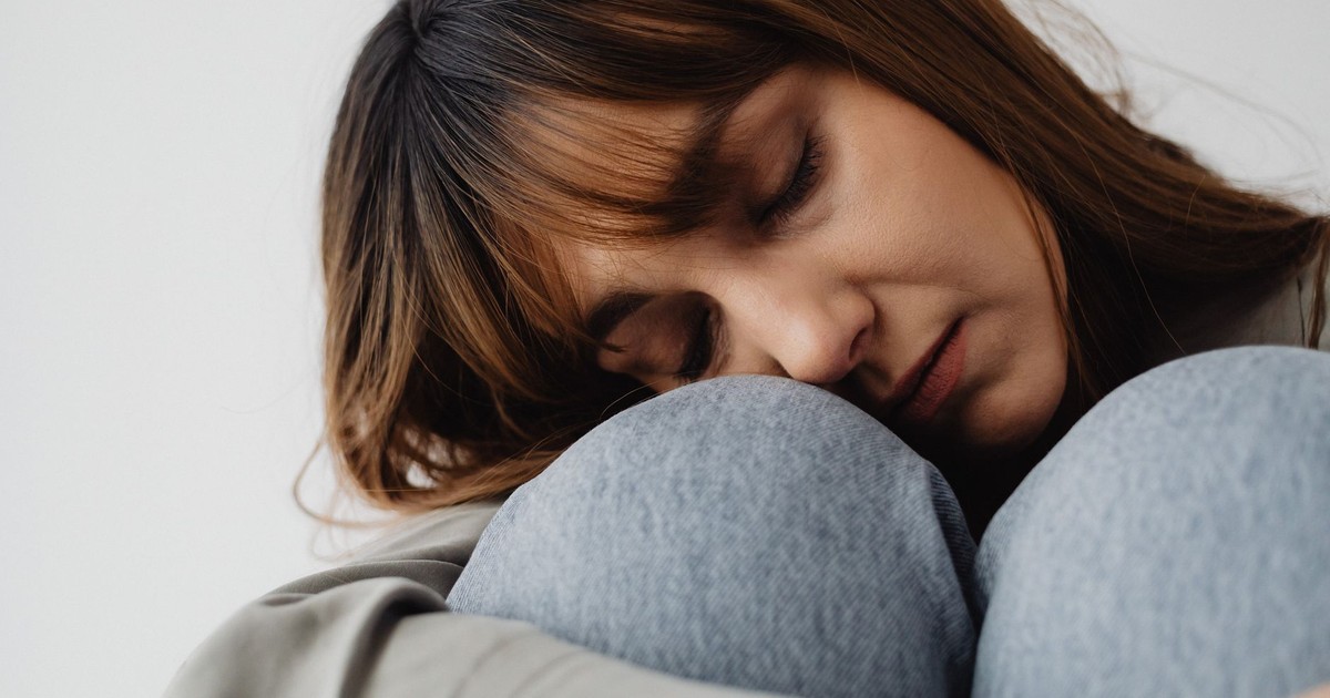 Serene close-up of a woman resting indoors, eyes closed, conveying peace and relaxation.