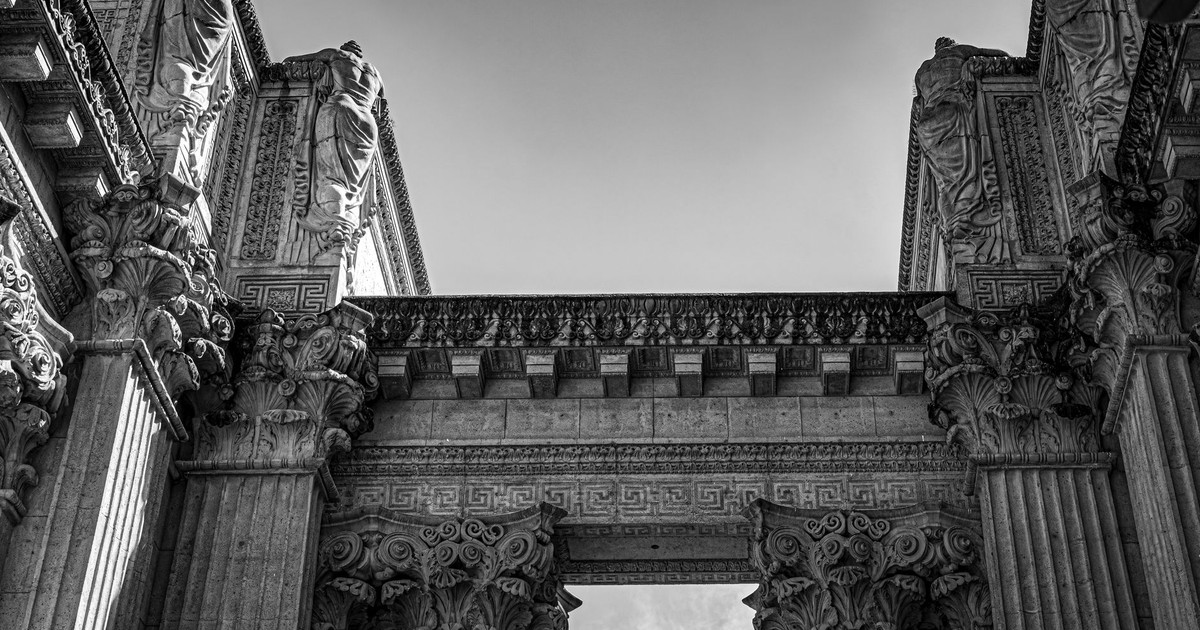 Black and white photo of historic columns and sculptures with intricate details.