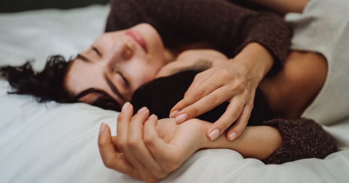 Close-up of a couple embracing on a bed, conveying warmth and intimacy in a peaceful setting.