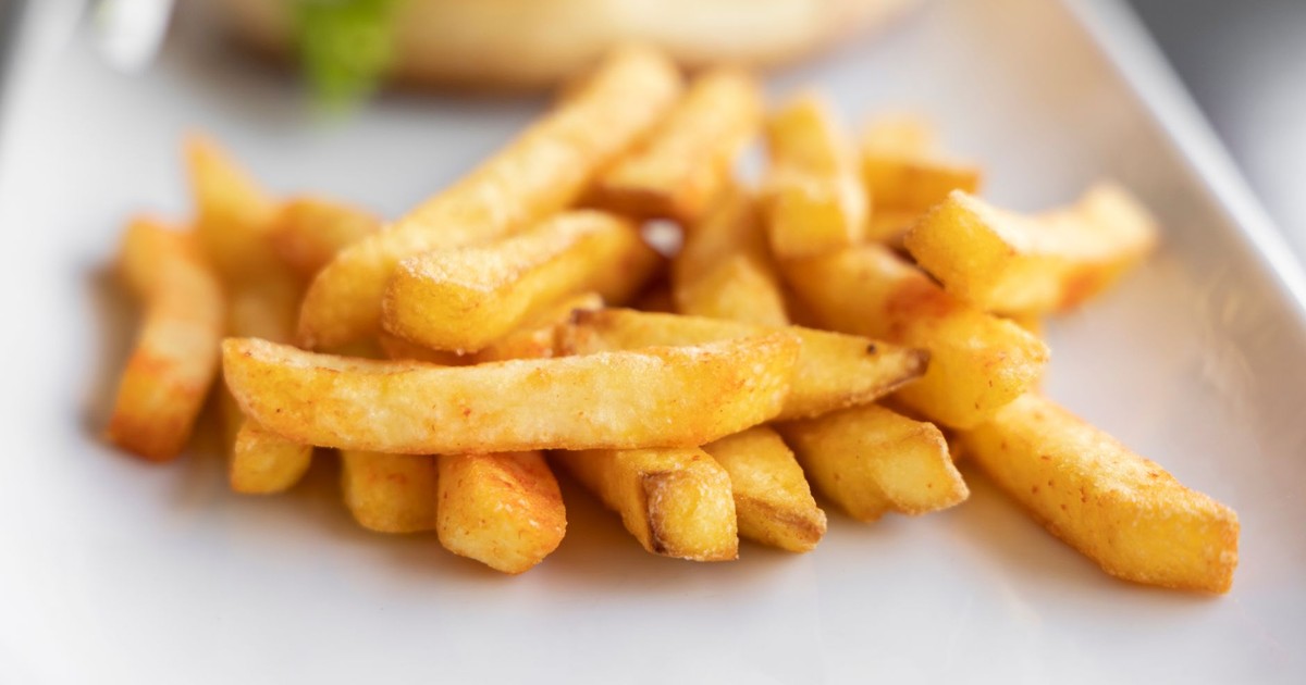 Close-up of crispy golden french fries served on a plate, perfect for finger food.