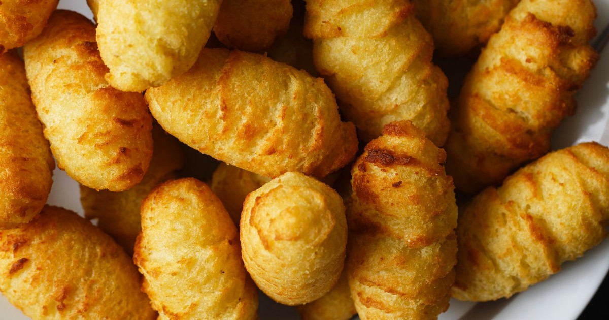 A close-up view of golden-brown crispy potato croquettes freshly served on a white plate.