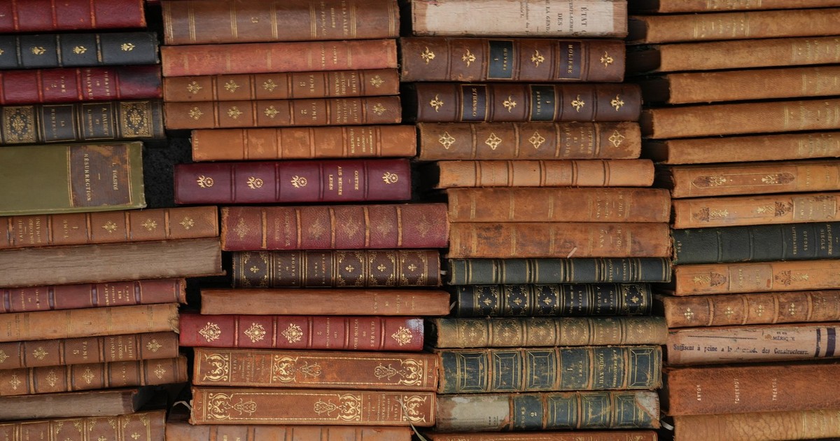 Stack of vintage leather-bound books with ornate designs, reflecting history and literature.