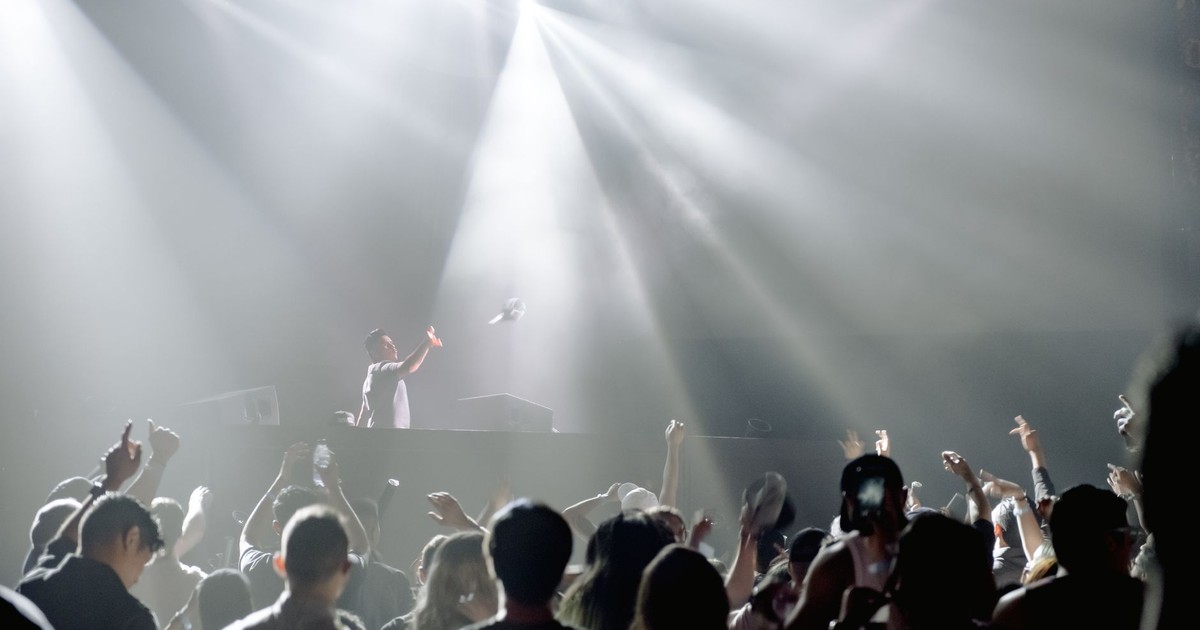DJ performing in a lively nightclub with a crowd enjoying the vibrant atmosphere.