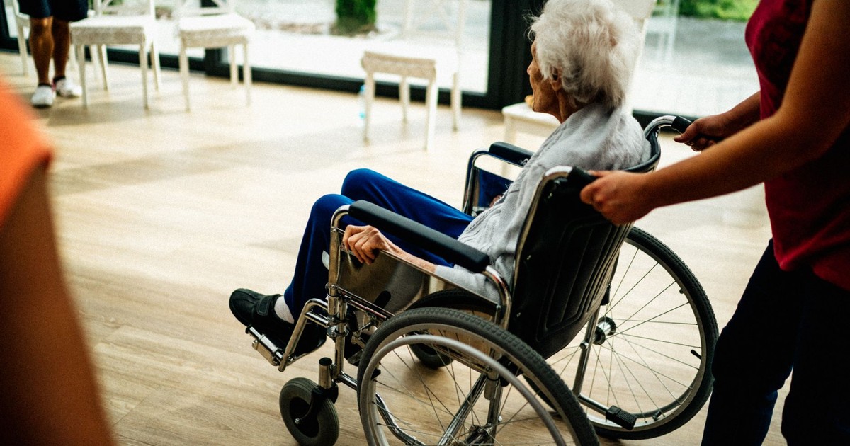 A caregiver assists a senior adult in a wheelchair at a nursing home in Prague, Czech Republic.