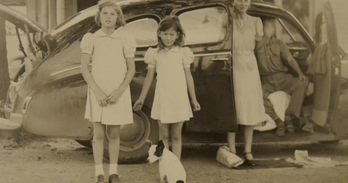 two girls and man and woman near house