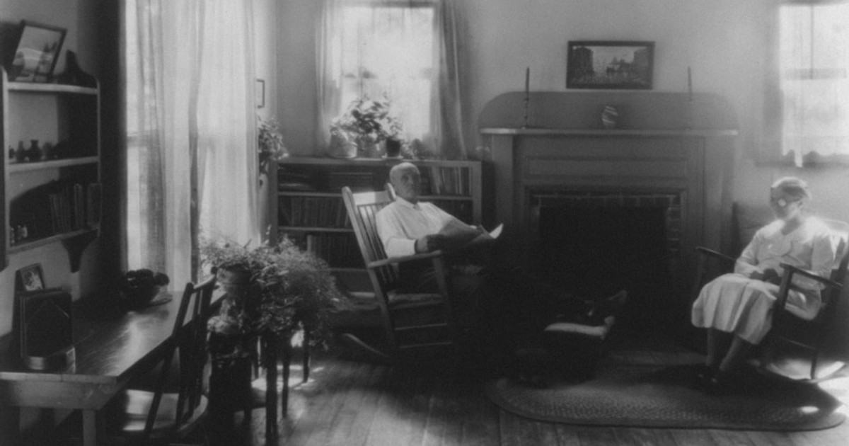Man and woman in rockers by fireplace