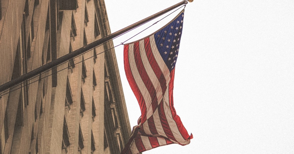 an american flag is hanging from a building