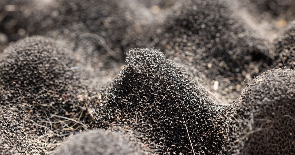 Detailed close-up of a dark, textured synthetic sponge surface showcasing intricate patterns.