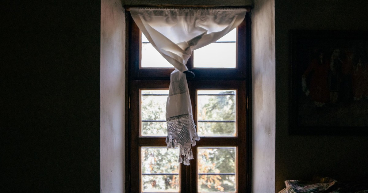 Charming window with sunlight streaming through vintage curtains in Elazığ, Türkiye.