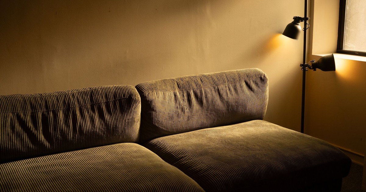 A corduroy sofa in a dimly lit room with a warm and inviting atmosphere.