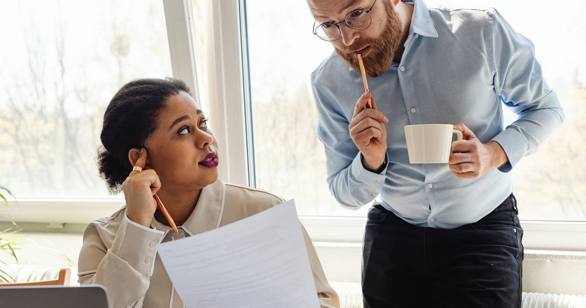 Two business colleagues reviewing documents together in a bright office.