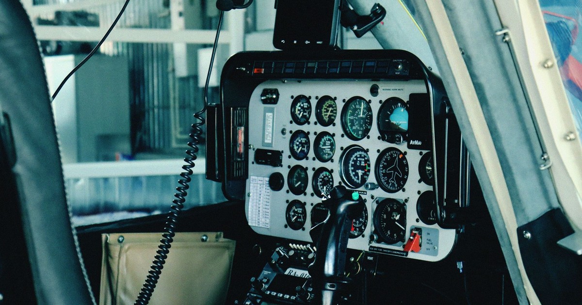 Detailed view of a helicopter's cockpit control panel with various gauges and navigational instruments.