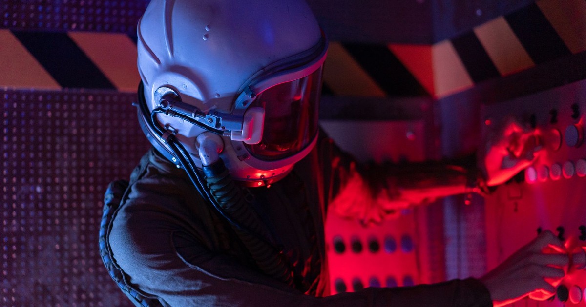 Astronaut in a spacesuit interact with controls in a dimly lit spacecraft cabin, exploring sci-fi themes.