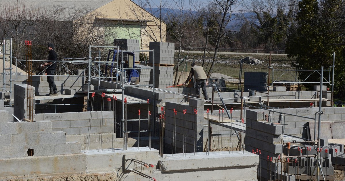 Construction workers building a concrete structure at a sunlit site.