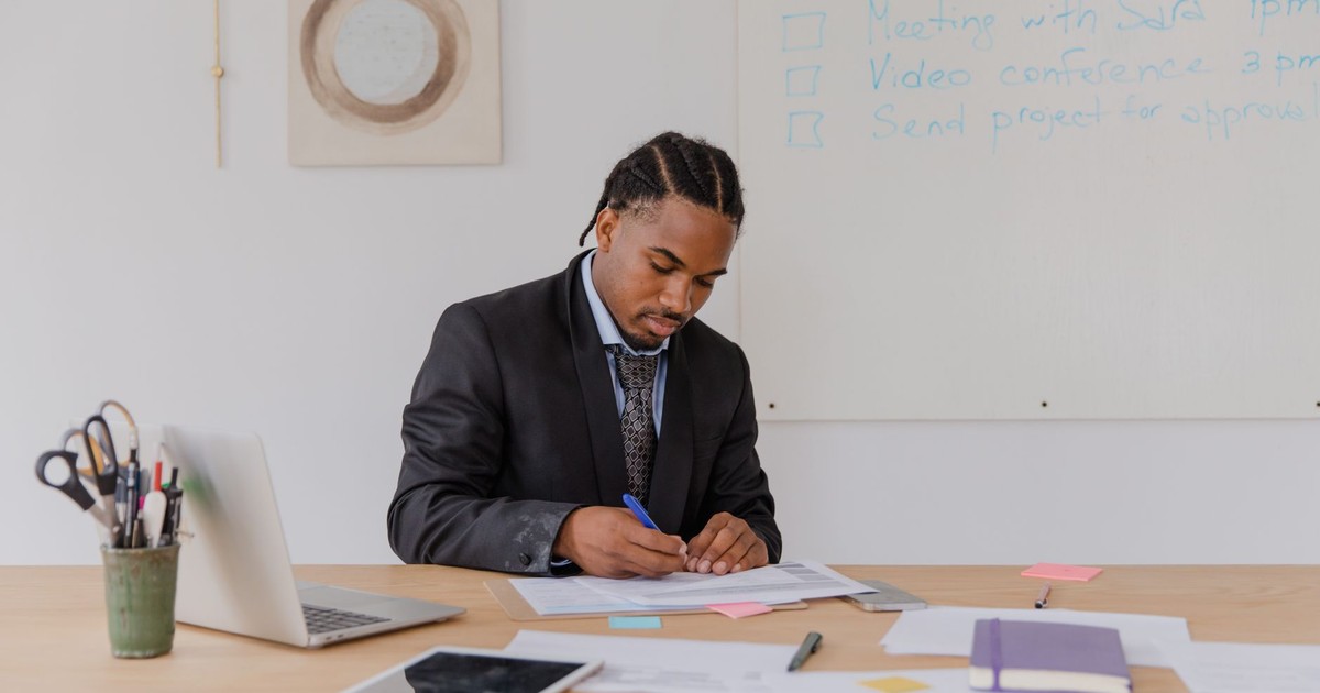 Professional man reviewing documents at his office desk with attention to detail.