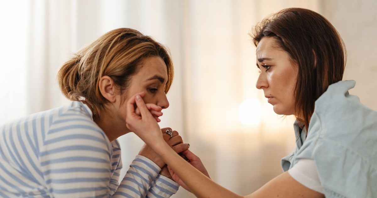 Two women comfort each other, depicting empathy and support in an intimate setting.