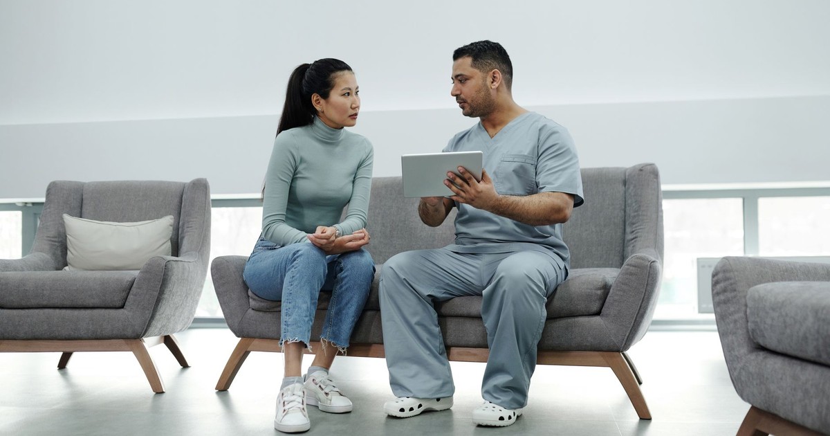 Healthcare provider consulting a patient with a tablet, emphasizing technology in healthcare.