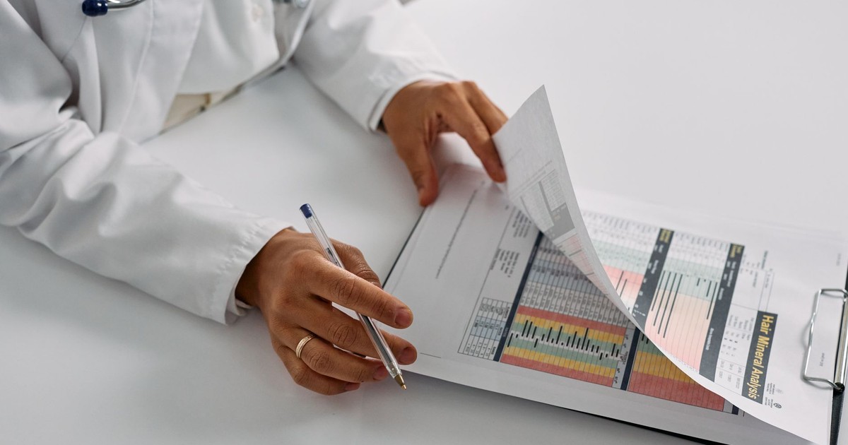 A medical professional checking patient reports with a clipboard in an office setting.