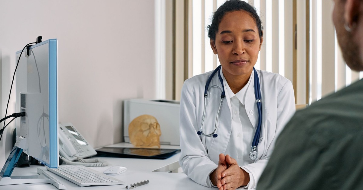 A female doctor consulting a patient in a modern medical office setting.