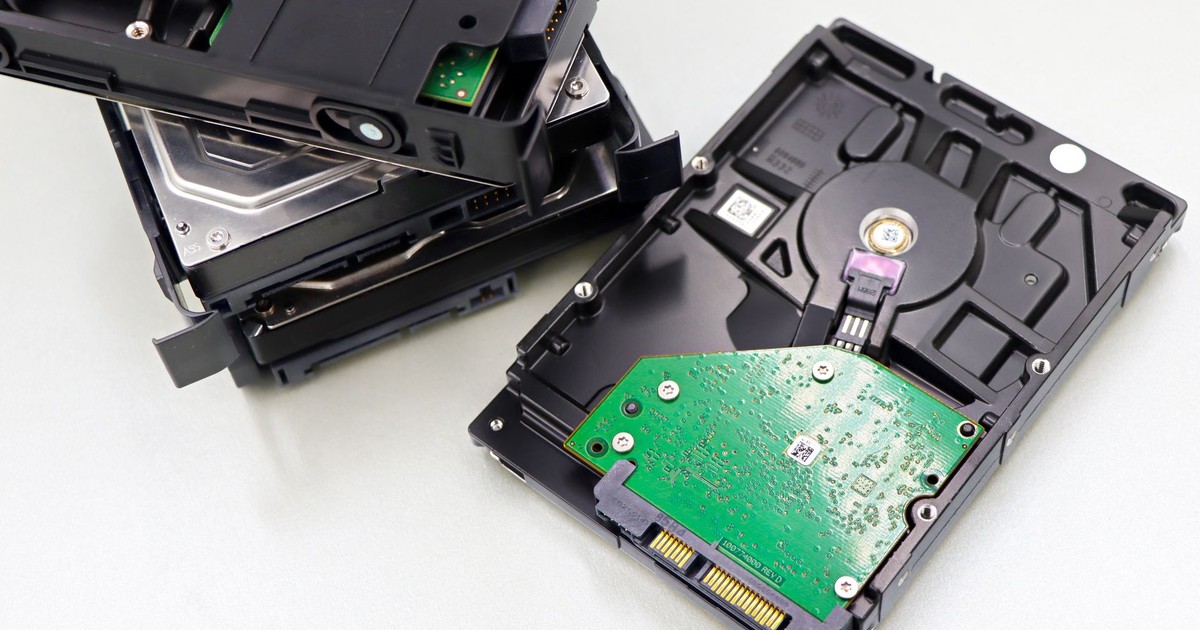 A collection of dismantled hard disk drives displayed on a white surface, showcasing internal components.