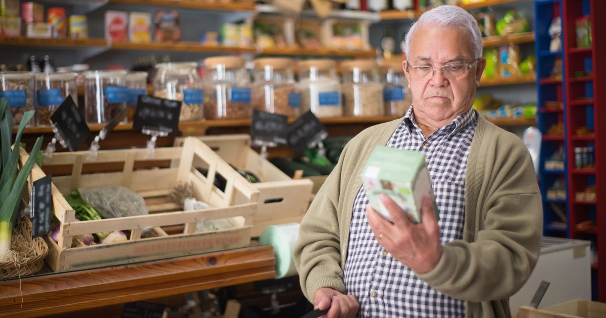 Senior man inspecting a product in a traditional Portuguese market.