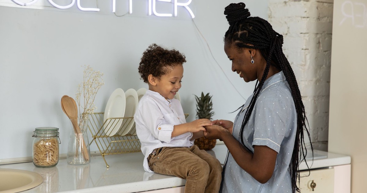 Warm moment between mother and son sitting in a stylish kitchen, sharing happiness.