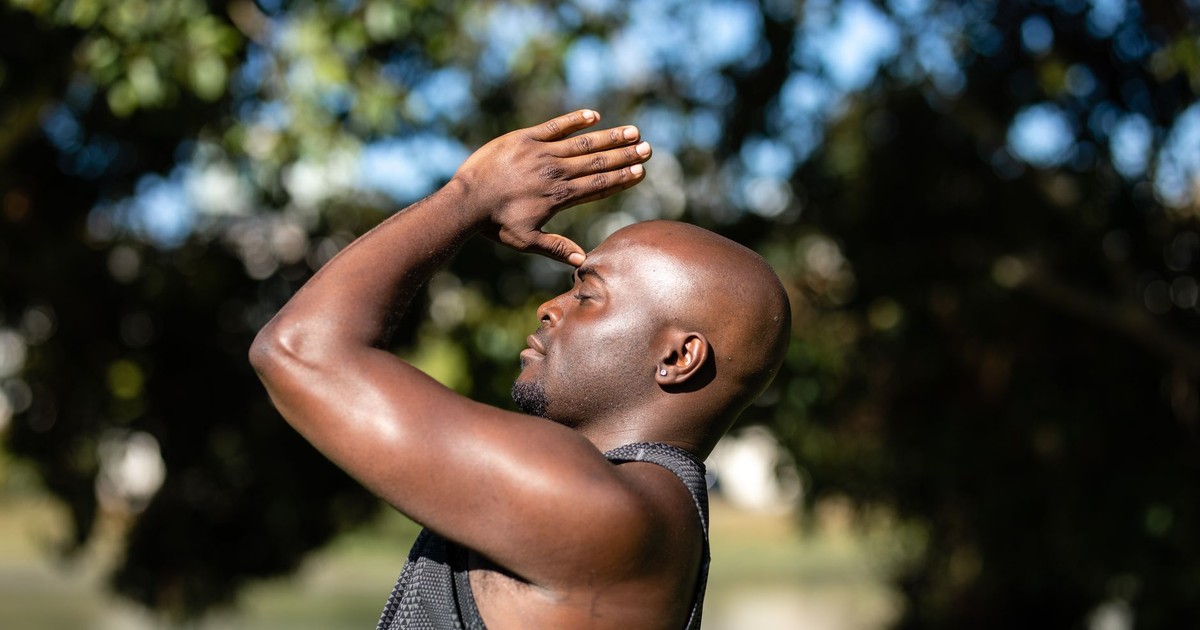 Close-up of a bald African American man meditating outdoors, embracing a healthy lifestyle.