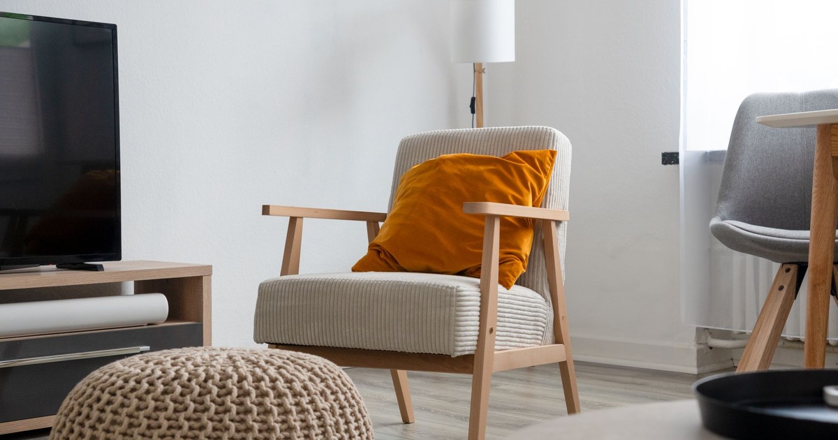 Modern living room interior featuring a comfy armchair, plush pillow, and sleek furniture.