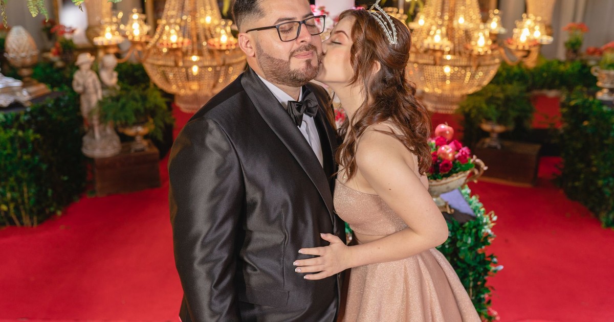 A couple dressed elegantly enjoys a luxurious indoor celebration, surrounded by ornate decor and vibrant lighting.