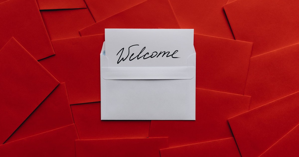 A white card with 'Welcome' text in an envelope against a red envelope background.
