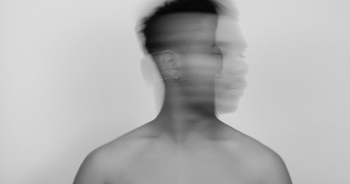 Creative portrait of a shirtless man with motion blur effect against a white background.